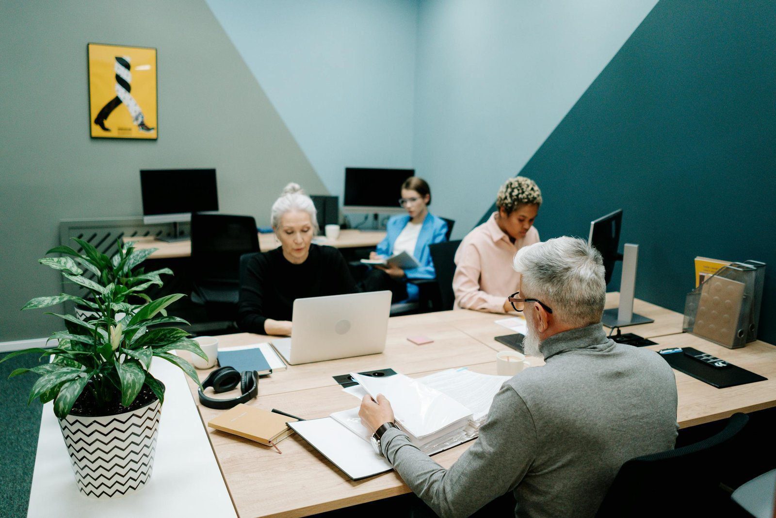 A diverse group of professionals working together in a modern office environment, focusing on teamwork and collaboration.